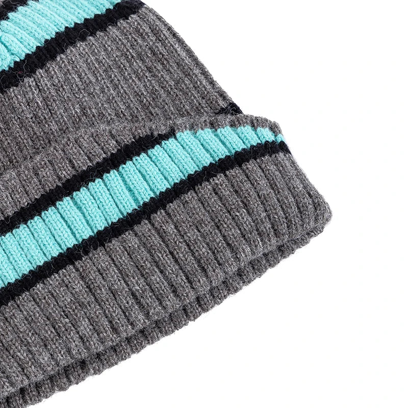 Close-up of a gray and teal striped beanie on a white background