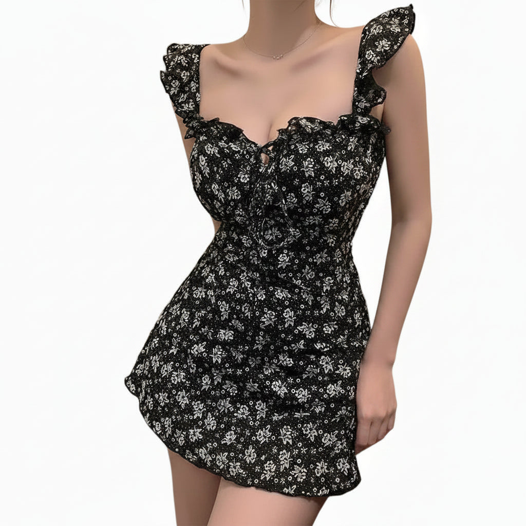 Black floral swim dress worn by a person, with a neutral background