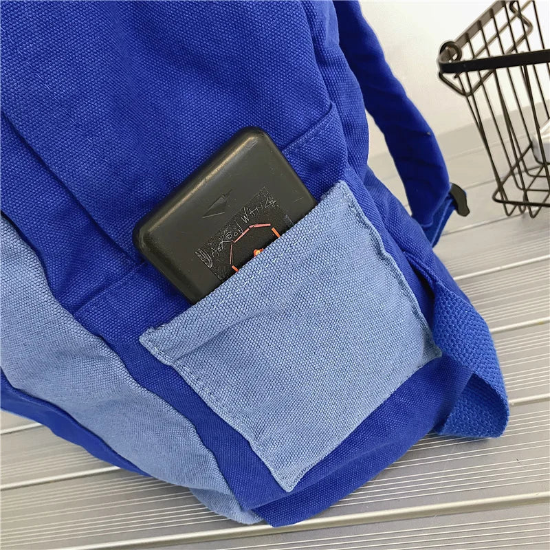Blue backpack with a pocket containing a cell phone.