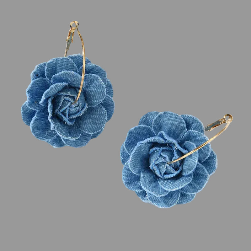 Blue flower-shaped earrings on a gray background
