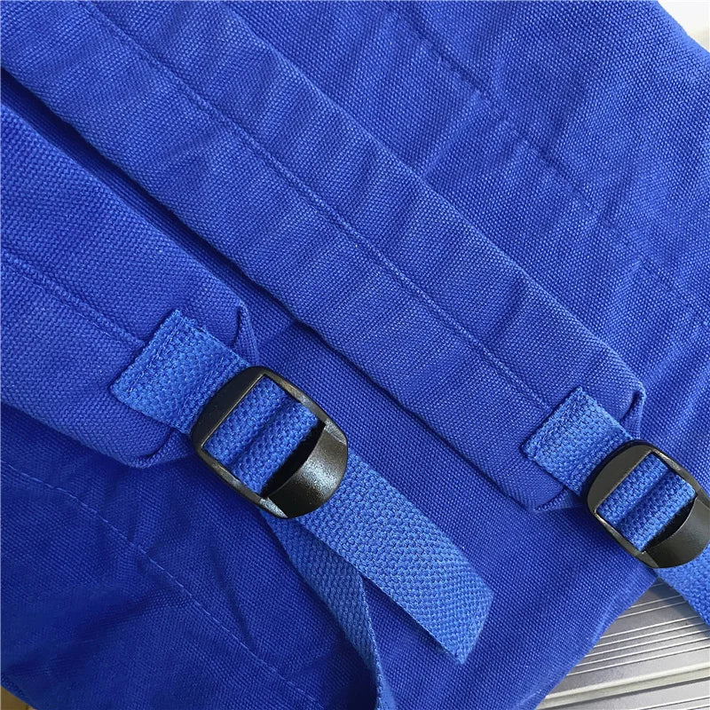 Close-up of blue fabric with black buckles on a textured surface