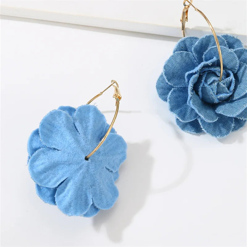 Blue flower-shaped earrings on a white background