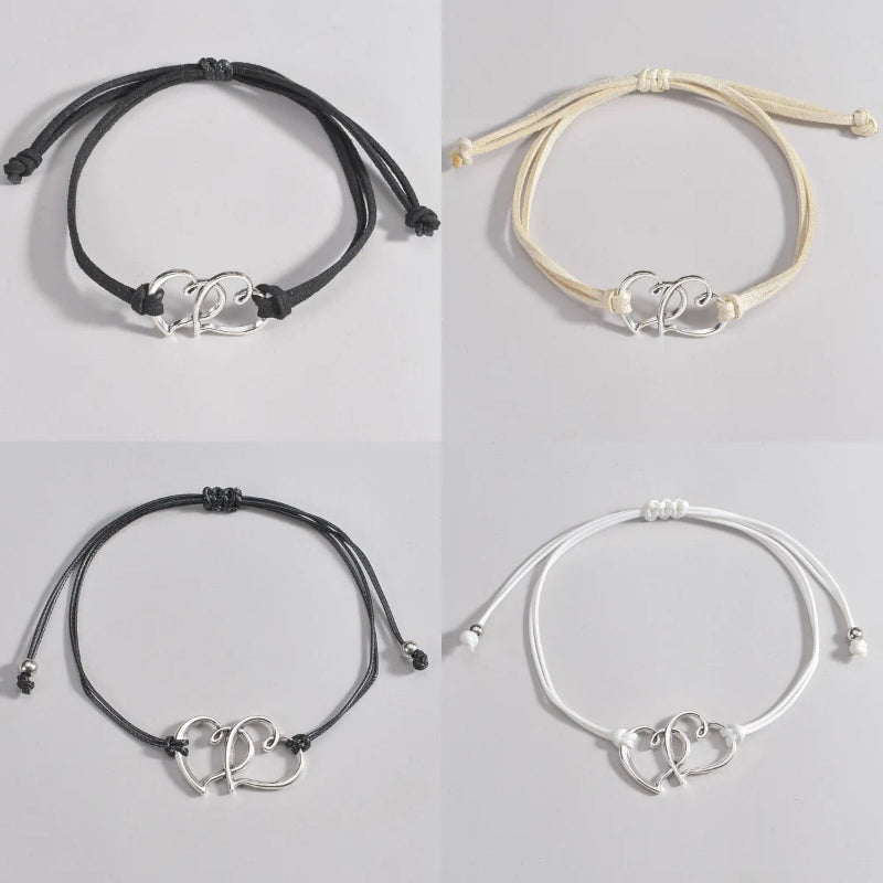 Four ankle bracelets with heart-shaped charms on a gray background