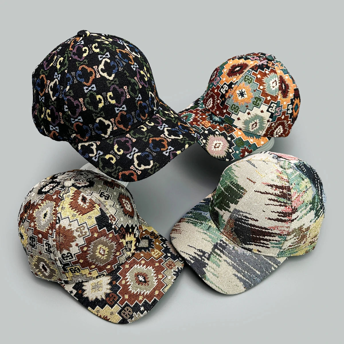 Three patterned baseball caps arranged in a staggered formation on a gray background
