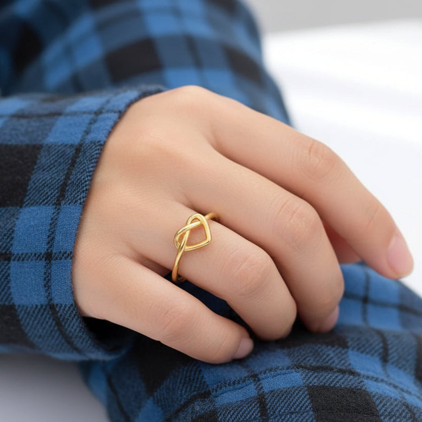 Gold ring on a finger with a blue plaid fabric background
