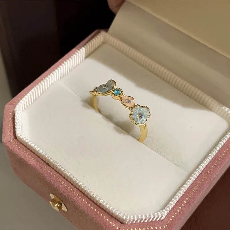 Gold ring with gemstones in a pink jewelry box