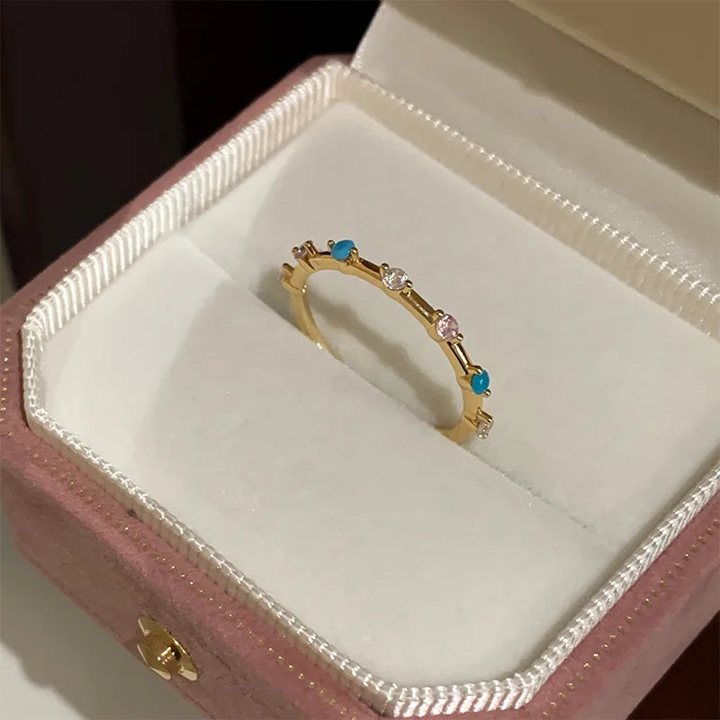 Gold ring with gemstones in a pink jewelry box