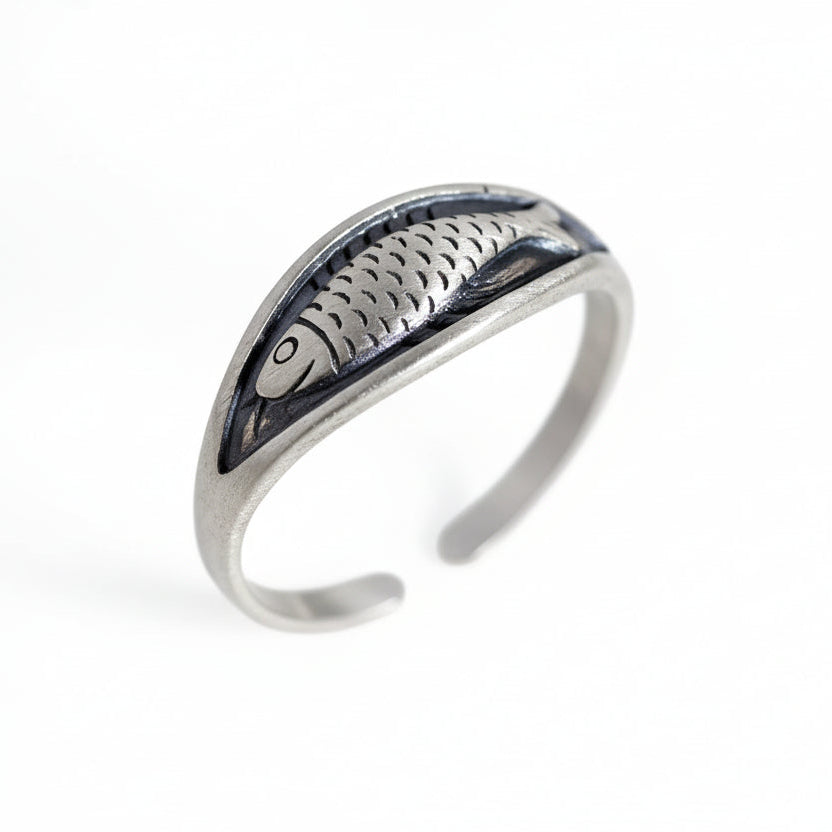Silver ring with fish design on a white background