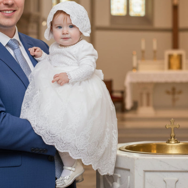 Man holding a baby in a church setting with stained glass windows and a baptismal font.