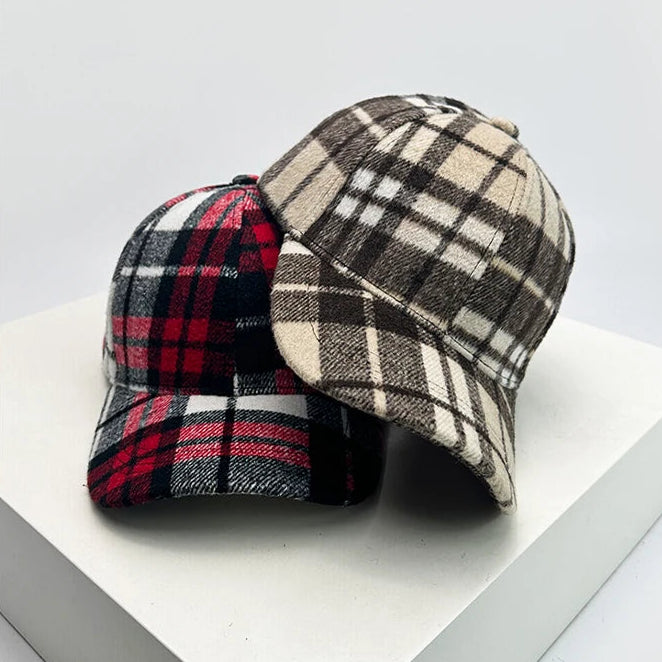 Two plaid hats on a white surface with a gray background