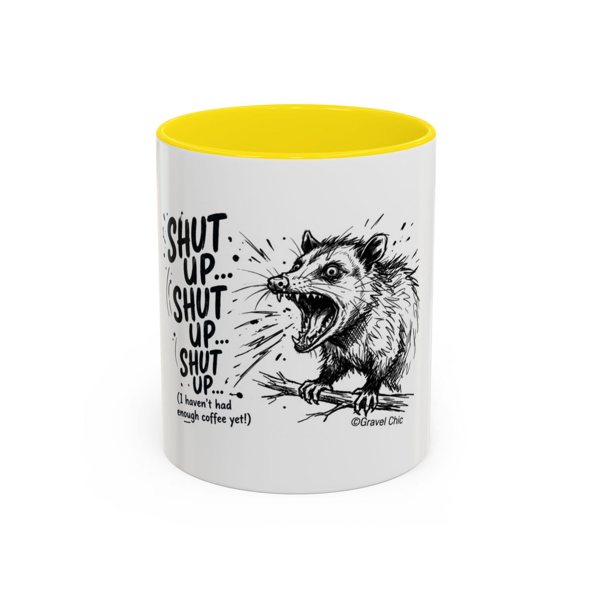 A white ceramic mug with a bright yellow interior, featuring a black line art illustration of a snarling opossum and the text 'SHUT UP.