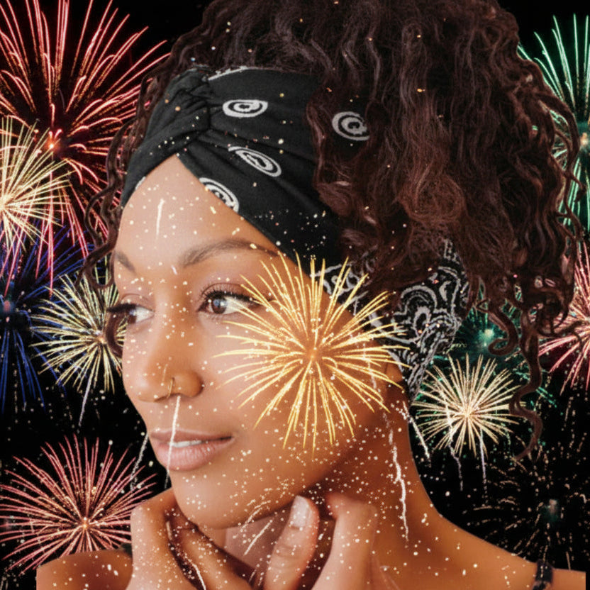 Woman wearing a black bandana-style headband with white patterns with fireworks 