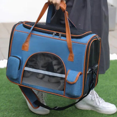 Blue pet carrier with brown accents being carried by a person.