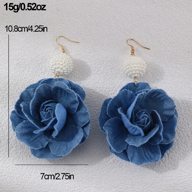 Blue flower earrings with measurements on a textured white background