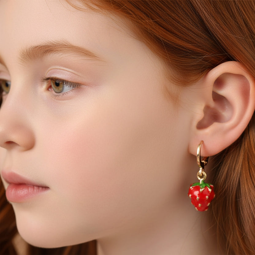 Close-up of a child wearing a strawberry-shaped earring.